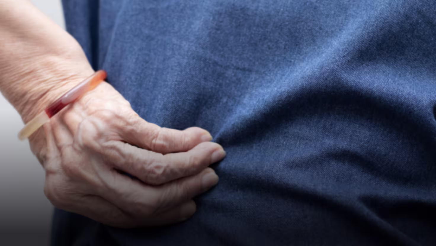 Person holding injured back showing pain from personal injury accident requiring medical treatment and compensation