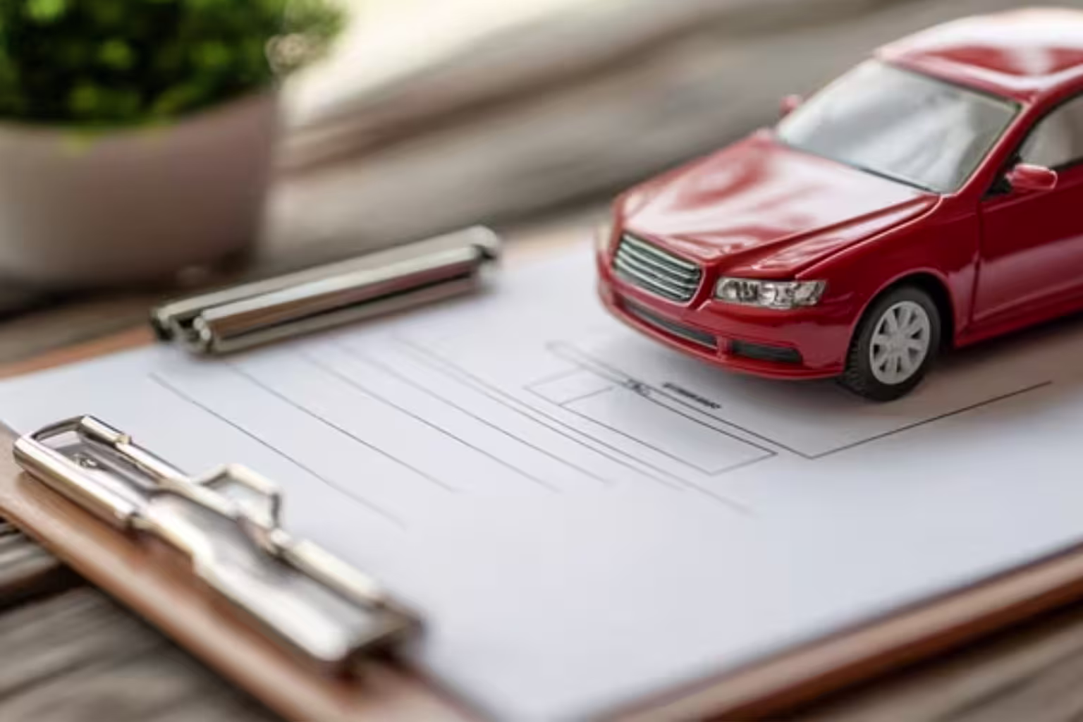 Red toy car sitting on legal documents and paperwork, illustrating the documentation and record-keeping involved in at-fault car accidents and their impact on Texas driving records