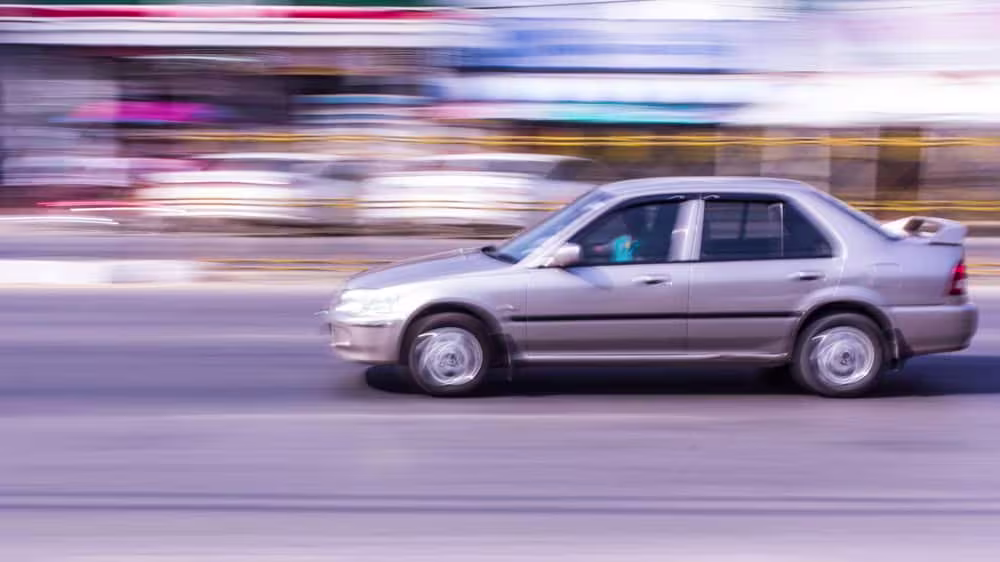 Blurred motion photo of car showing reckless driving in Texas that could result in comparative negligence claims and shared fault in personal injury cases