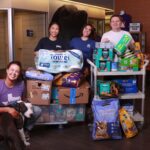 Angel Reyes & Associates team members Vanessa Dinh, Priscila Goicochea, and Attorney Andy Truelove pose with SPCA of Texas staff during pet supply donation delivery in Dallas