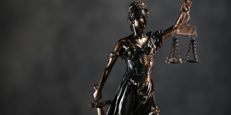 Statue of a woman holding a balance on her left arm