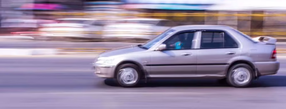 Blurred motion photo of car showing reckless driving in Texas that could result in comparative negligence claims and shared fault in personal injury cases