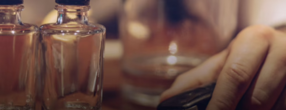 "Person with car keys and alcohol bottles on table, illustrating the dangerous drunk driving decision that leads to serious accidents and settlement claims in Texas