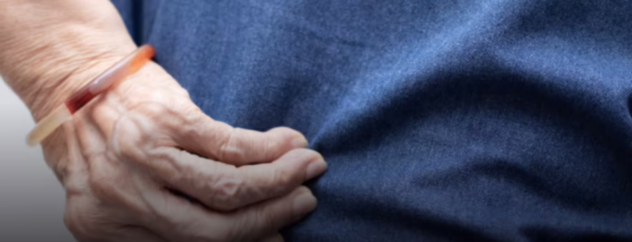 Person holding injured back showing pain from personal injury accident requiring medical treatment and compensation